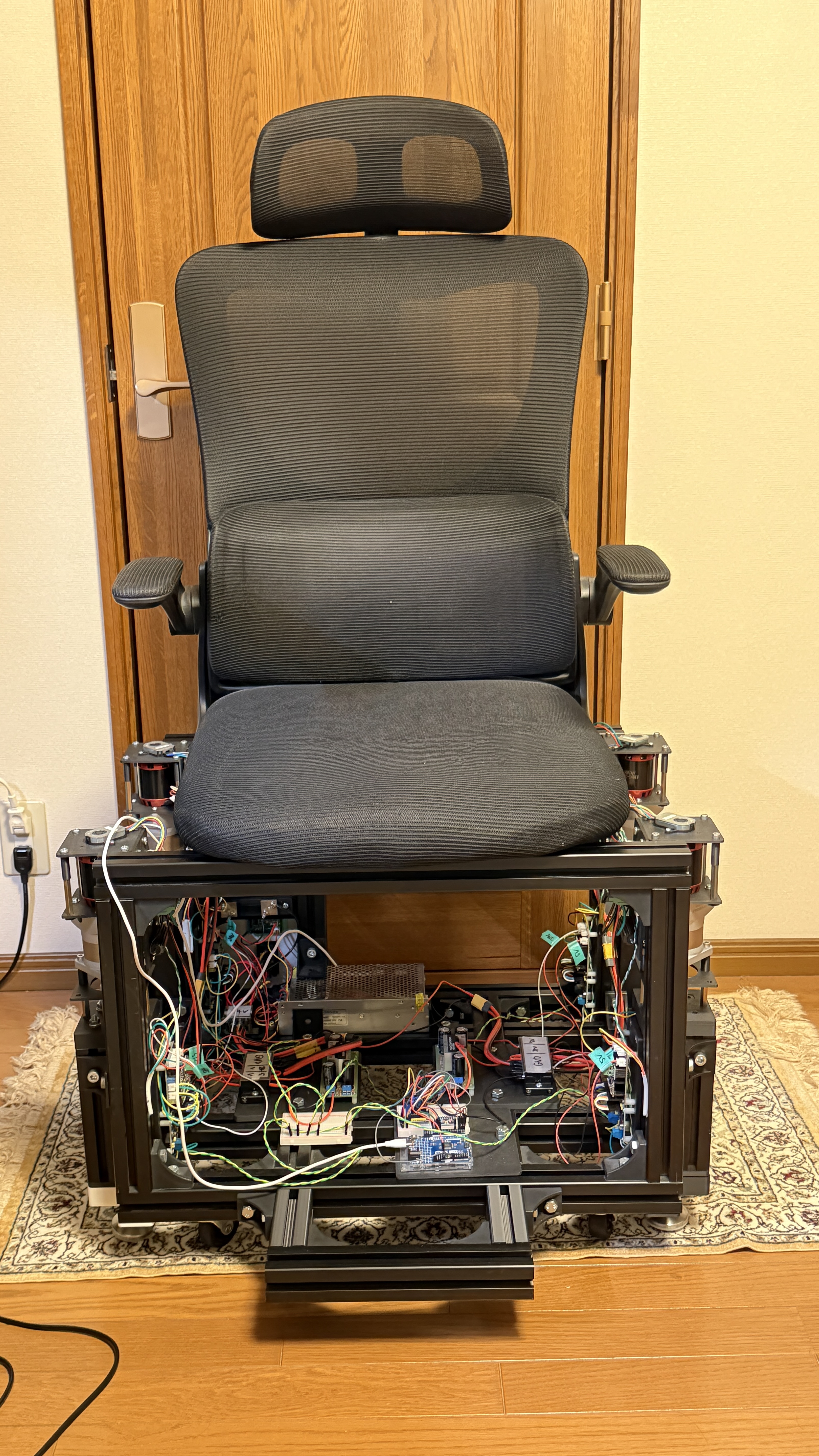 モーション機構を組み込んだ椅子の実機試作。座面の下にフレーム、駆動部、制御回路がある。